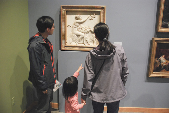 A family looking at art in the 19th Century Gallery